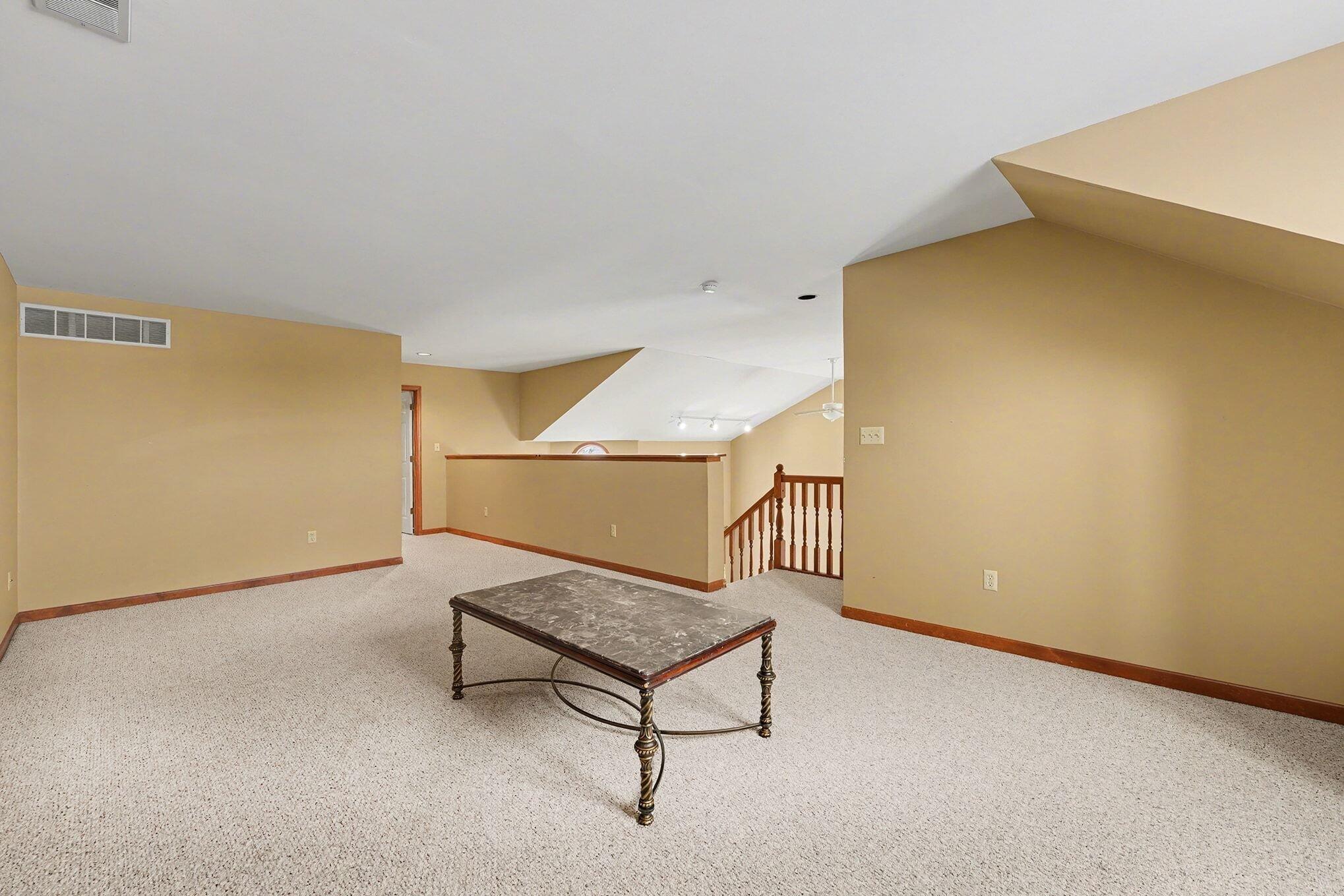 1341 West 94th Court Crown Point, IN 46307 - Photo 21 of 38 a living room with a table and paintings on the wall