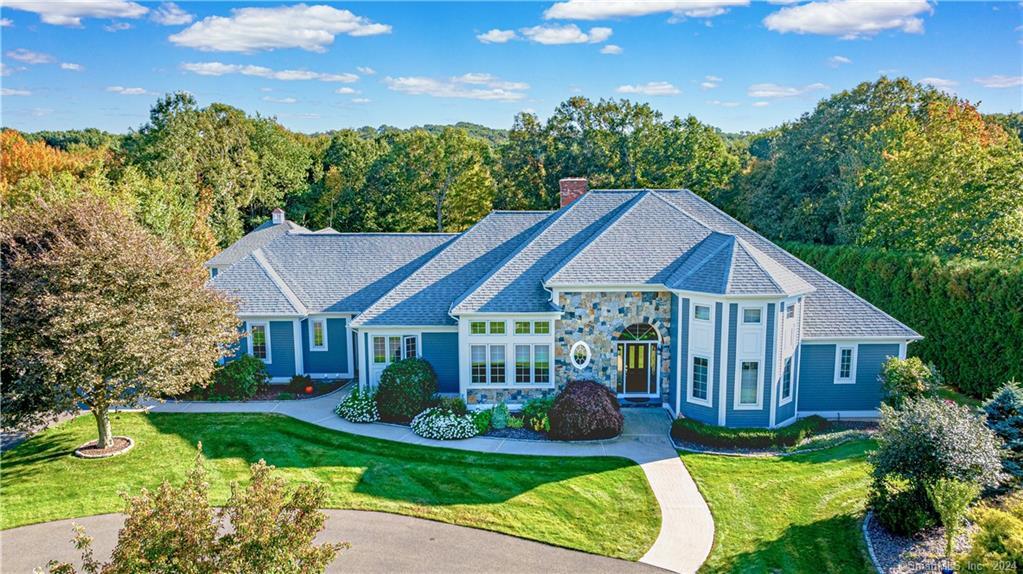 a view of a house with a big yard plants and large trees