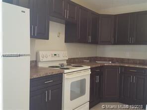 900 Avenue H, Unit 3 Riviera Beach, FL 33404 - Photo 2 of 2 a kitchen with a stove sink and cabinets