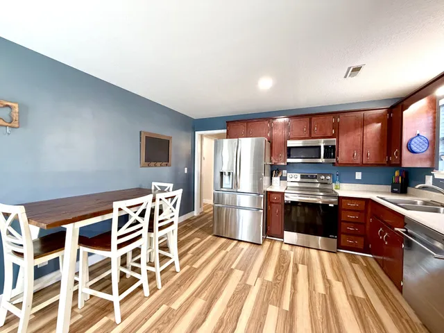 a kitchen with stainless steel appliances a refrigerator stove microwave and sink