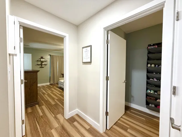 a view of a hallway with bathroom and wooden floor