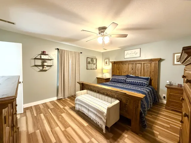 a bedroom with a bed and wooden floor