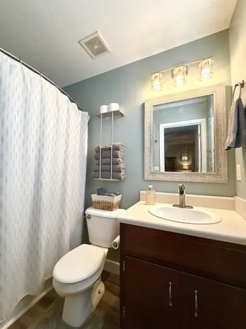 a bathroom with a toilet sink and mirror