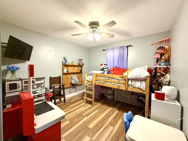 a room with furniture a flat screen tv and a ceiling fan