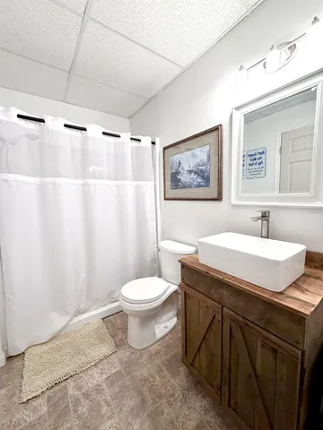 a bathroom with a granite countertop sink toilet and a mirror