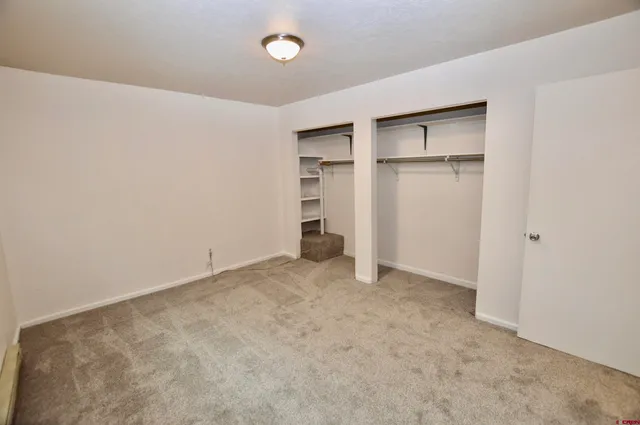 an empty room with closet and windows