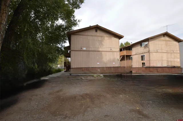 a view of a house with backyard and trees