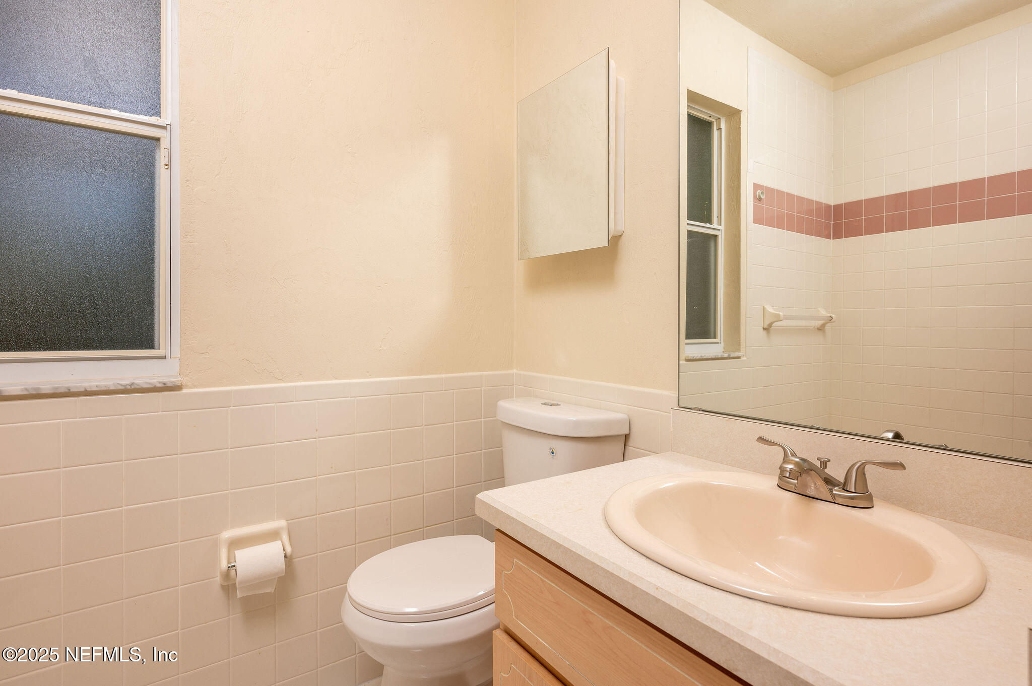 63 Hernandez Avenue Ormond Beach, FL 32174 - Photo 23 of 33 a bathroom with a sink a toilet and a mirror