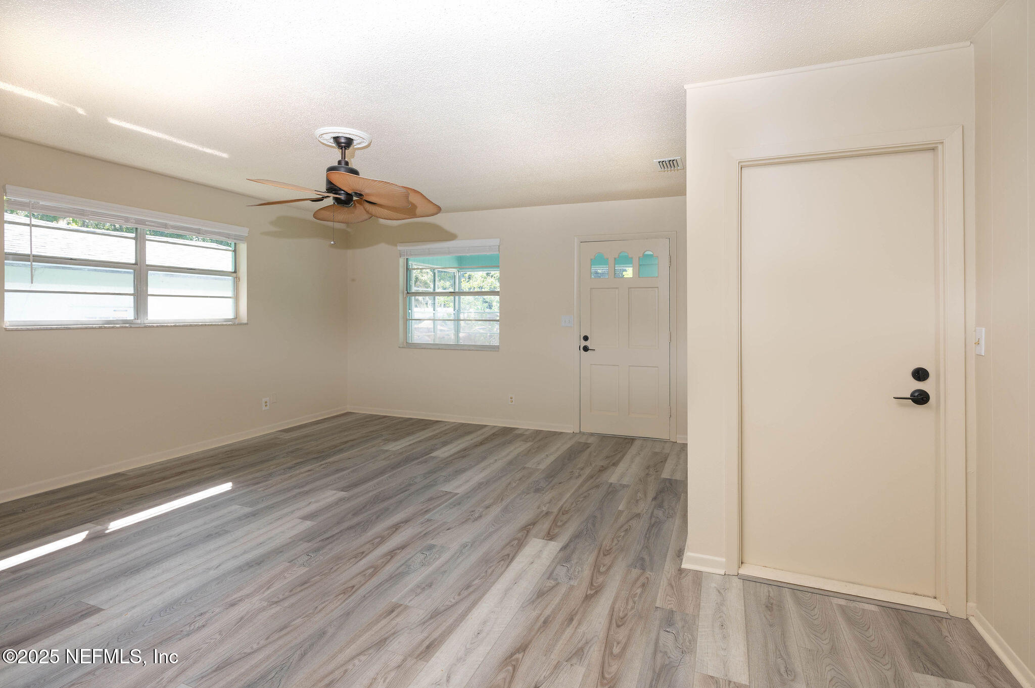 63 Hernandez Avenue Ormond Beach, FL 32174 - Photo 7 of 33 an empty room with wooden floor and windows