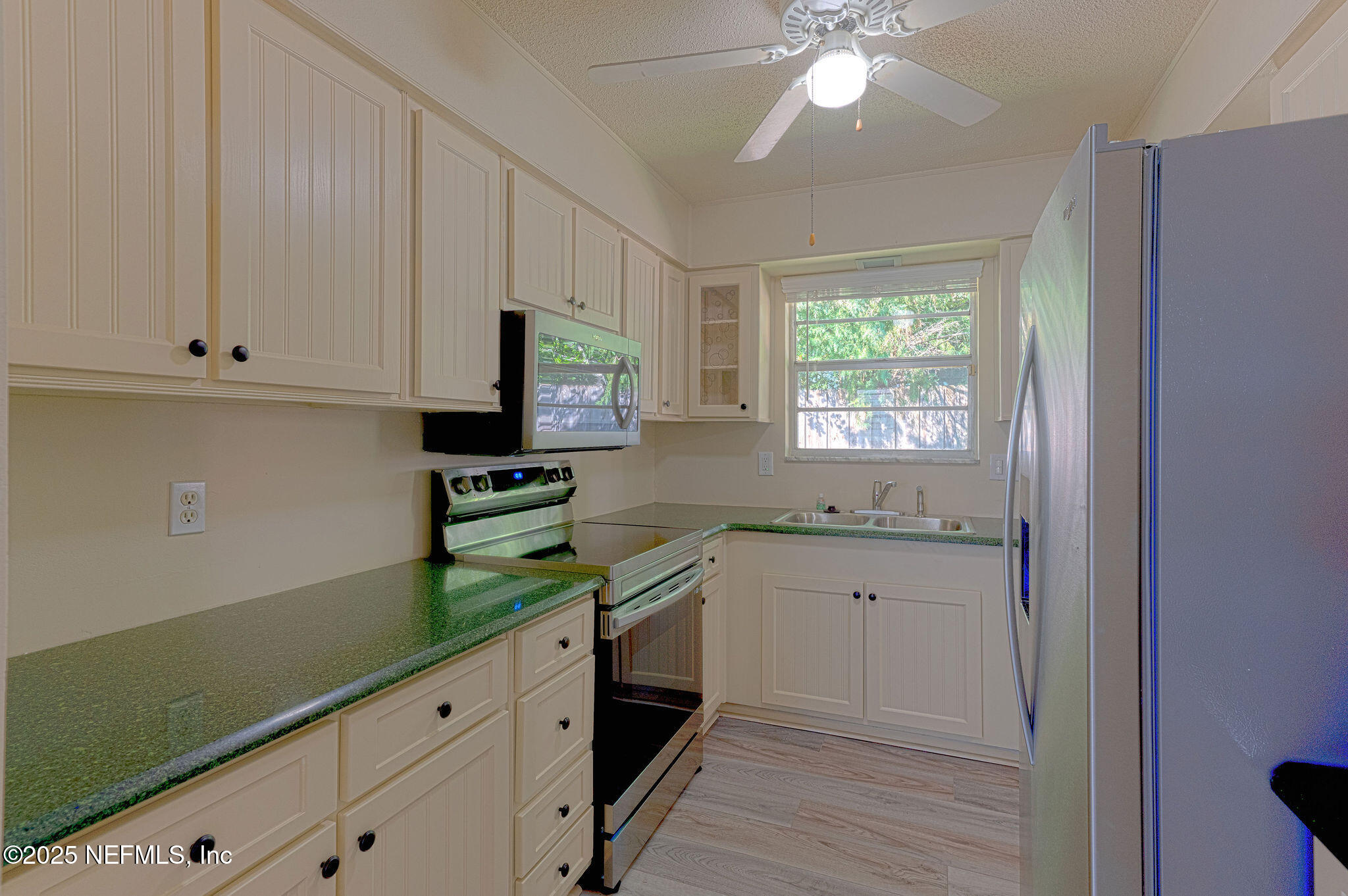 63 Hernandez Avenue Ormond Beach, FL 32174 - Photo 10 of 33 a kitchen with granite countertop white cabinets and white appliances