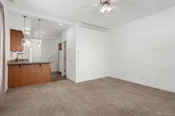 a view of an empty room and kitchen view