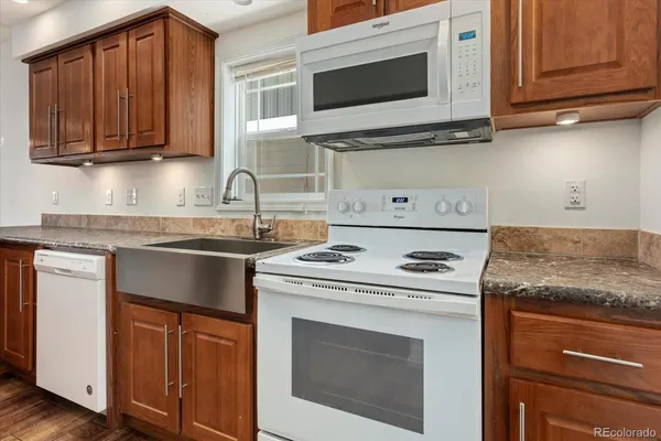 a kitchen with granite countertop cabinets stainless steel appliances and a sink