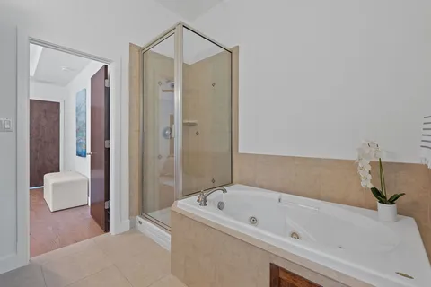 a bathroom with a tub a sink and a large mirror