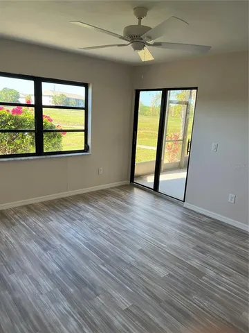 a view of empty room with wooden floor and fan