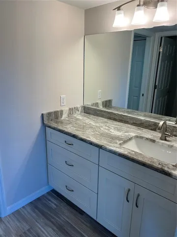 a bathroom with a granite countertop sink and mirror