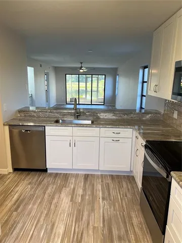 a kitchen with stainless steel appliances granite countertop a stove and white cabinets