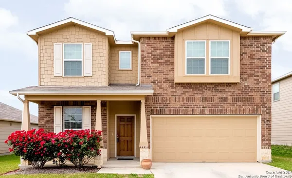 front view of a brick house with a yard