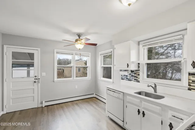 a view of a kitchen with a sink hardwood floor and a window