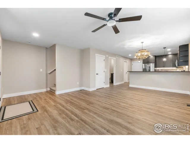 a view of an empty room and kitchen view