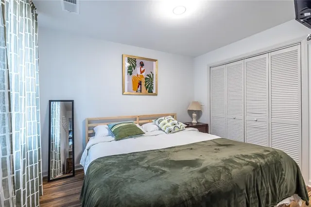 a bedroom with a bed and painting on the wall