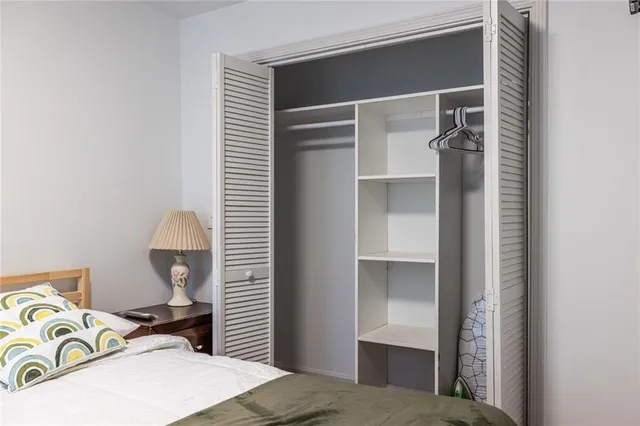 a bedroom with a bed and a lamp on the dresser