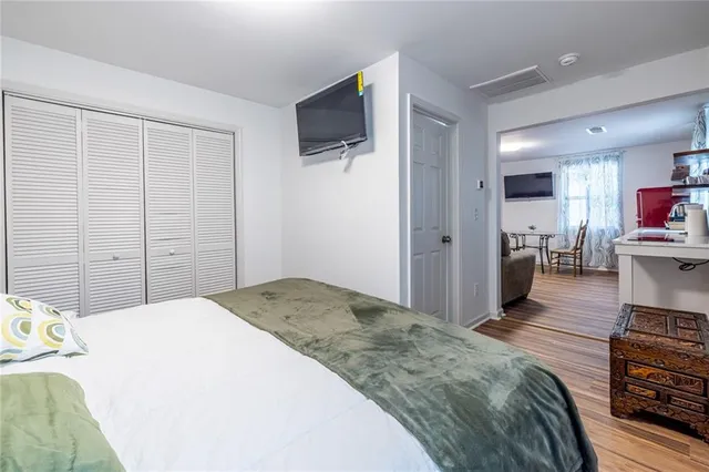 a spacious bedroom with a bed and a flat screen tv