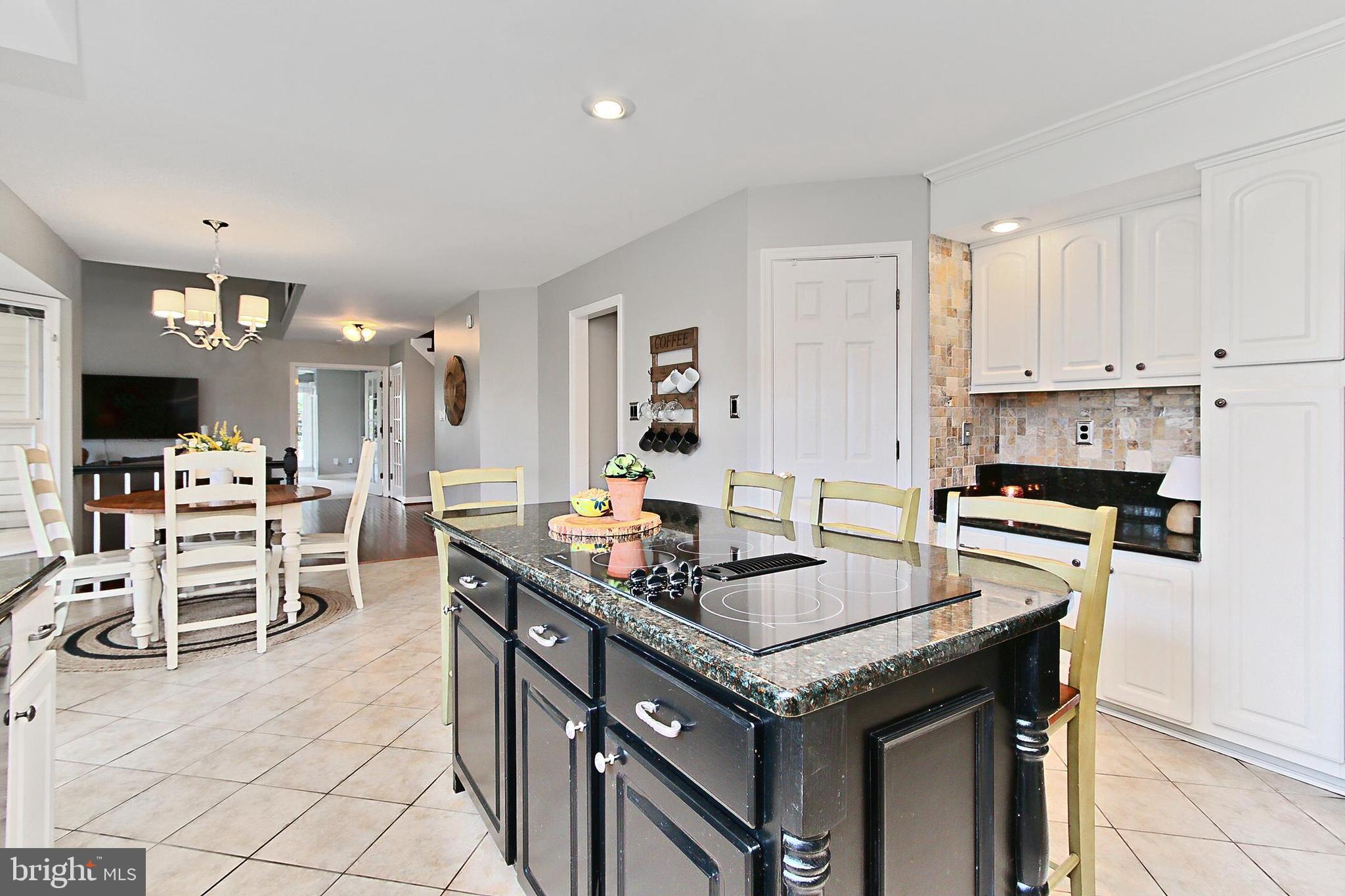6306 Lee Forest Path Centreville, VA 20120 - Photo 11 of 49 a kitchen with stainless steel appliances granite countertop a stove top oven a sink a dining table and chairs