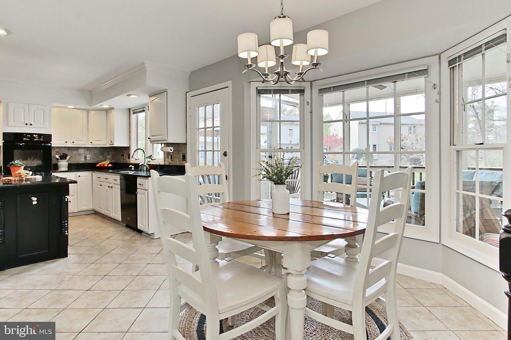 6306 Lee Forest Path Centreville, VA 20120 - Photo 12 of 49 a view of a dining room with furniture large windows and wooden floor