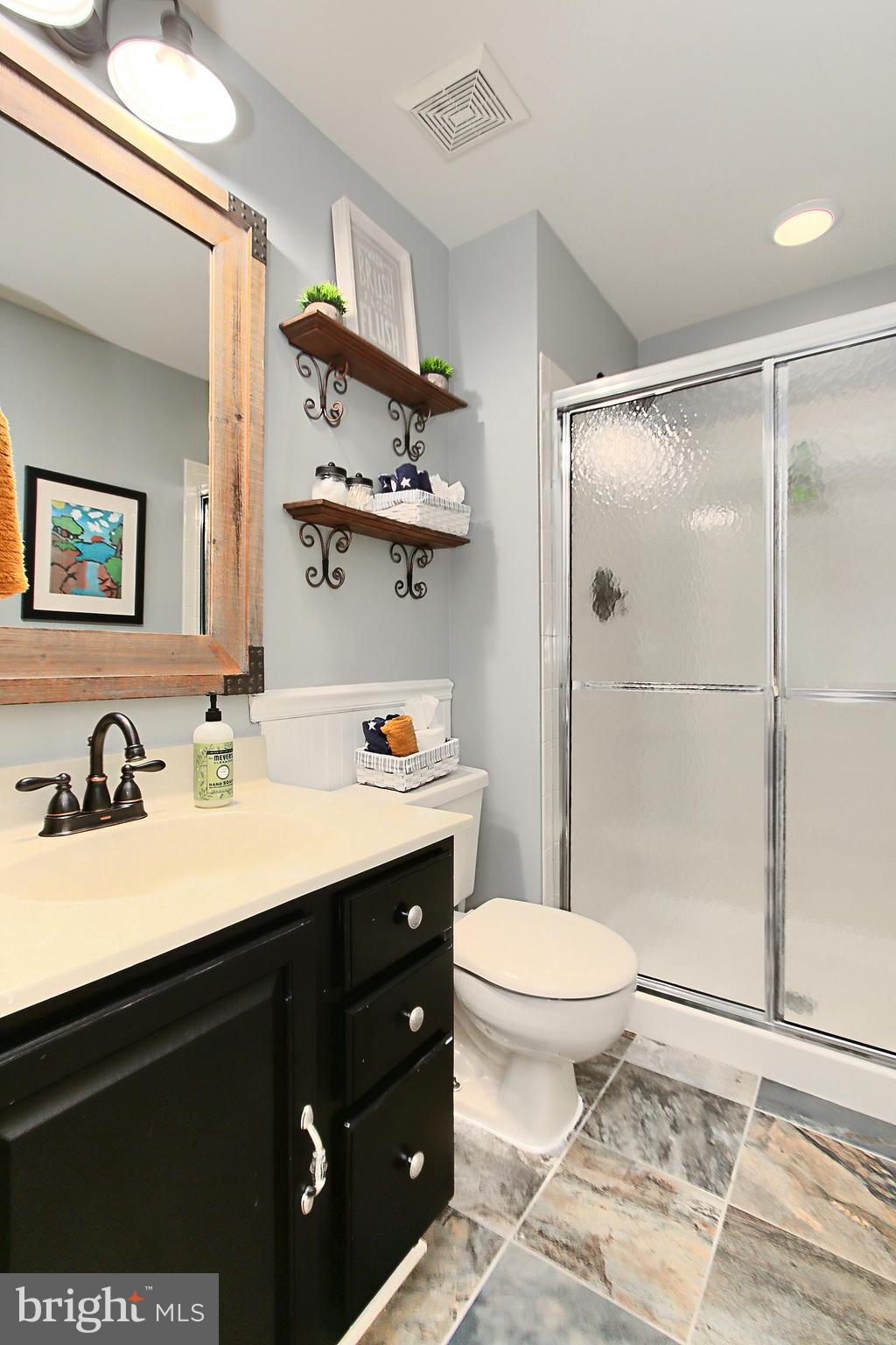 6306 Lee Forest Path Centreville, VA 20120 - Photo 41 of 49 a bathroom with a granite countertop sink toilet mirror and shower