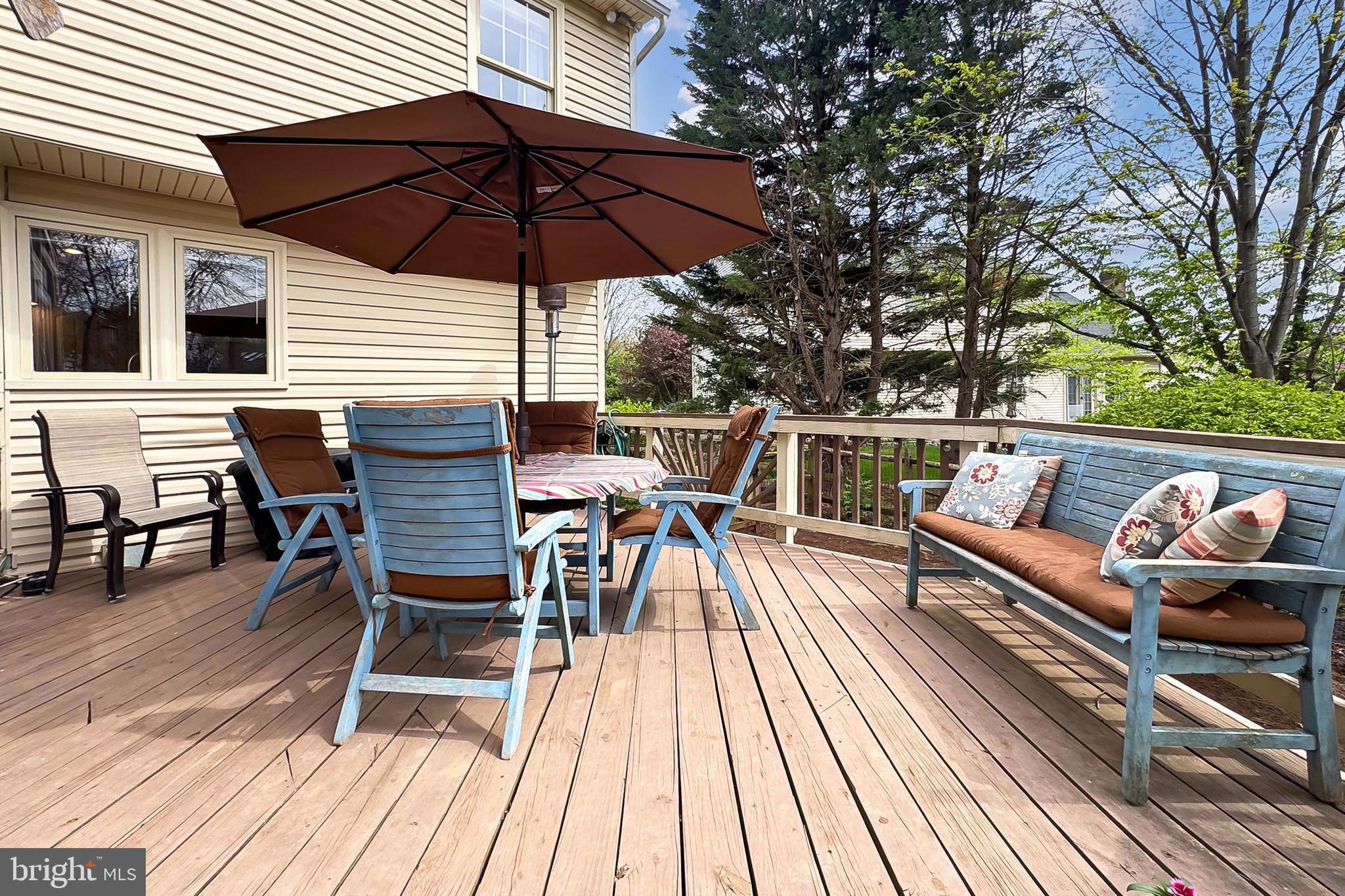 6306 Lee Forest Path Centreville, VA 20120 - Photo 44 of 49 a view of a roof deck with table and chairs under an umbrella with wooden floor and fence