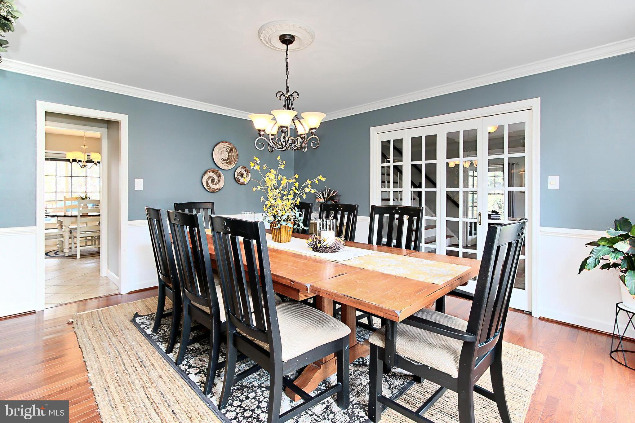 6306 Lee Forest Path Centreville, VA 20120 - Photo 8 of 49 a view of a dining room with furniture a chandelier and wooden floor