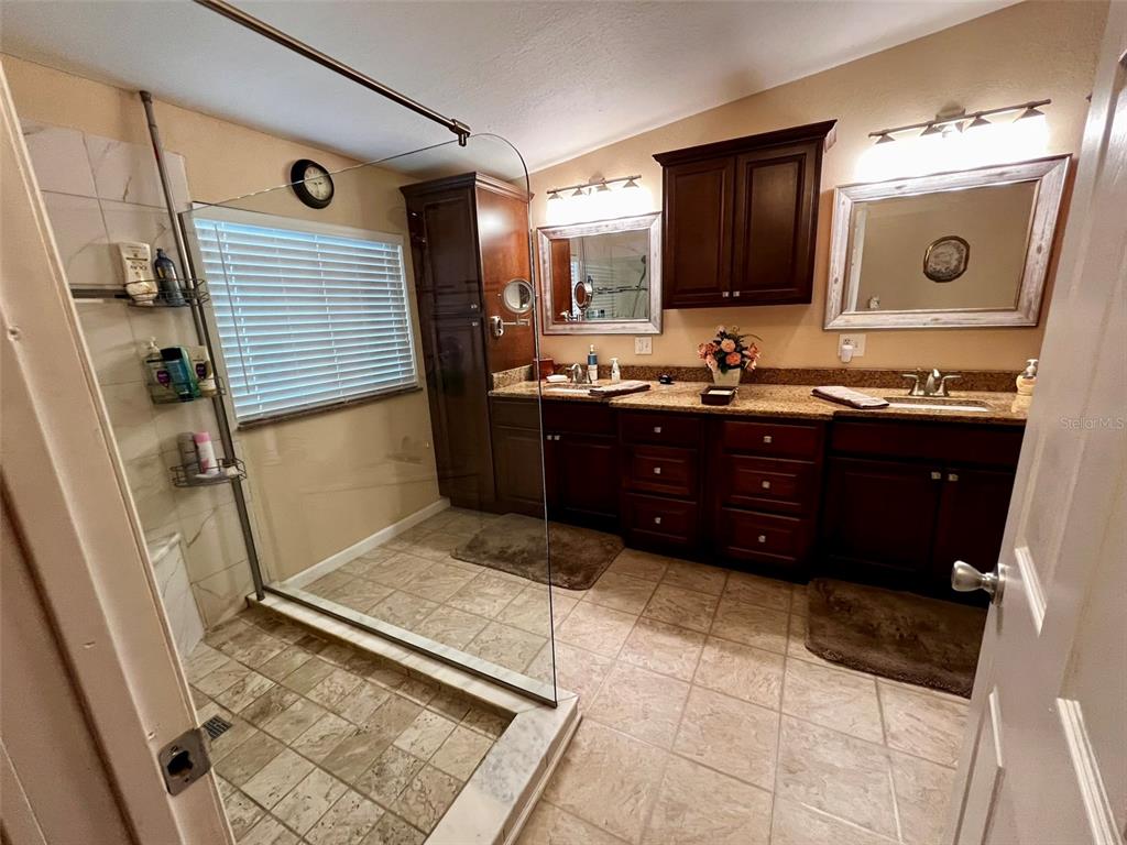 5601 Duncan Road, Unit 96 Punta Gorda, FL 33982 - Photo 13 of 30 a spacious bathroom with a granite countertop sink and a mirror