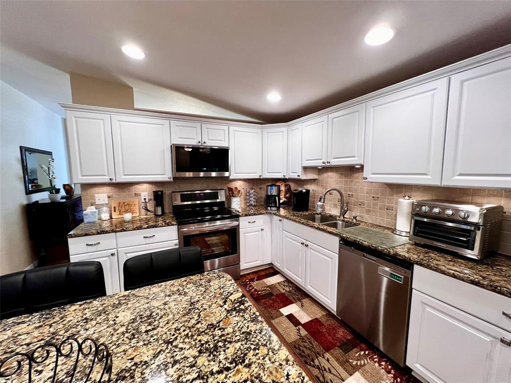 5601 Duncan Road, Unit 96 Punta Gorda, FL 33982 - Photo 7 of 30 a kitchen with granite countertop a refrigerator stove top oven and sink