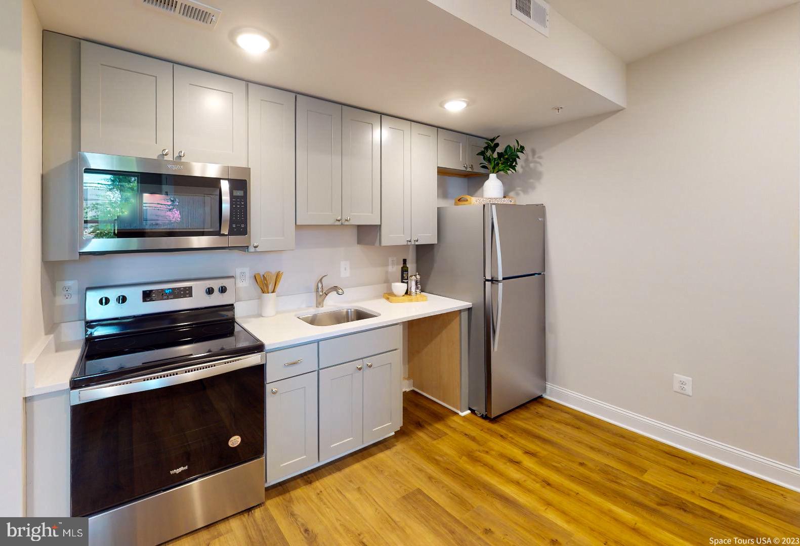 220 Hamilton Street Northwest, Unit 212 Washington, DC 20011 - Photo 2 of 11 a kitchen with a refrigerator stove and microwave