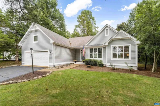 a front view of a house with a garden and yard