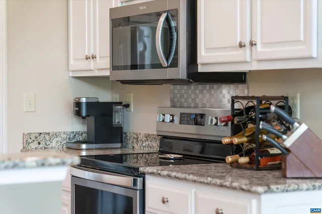 a kitchen with stainless steel appliances granite countertop a sink refrigerator and cabinets