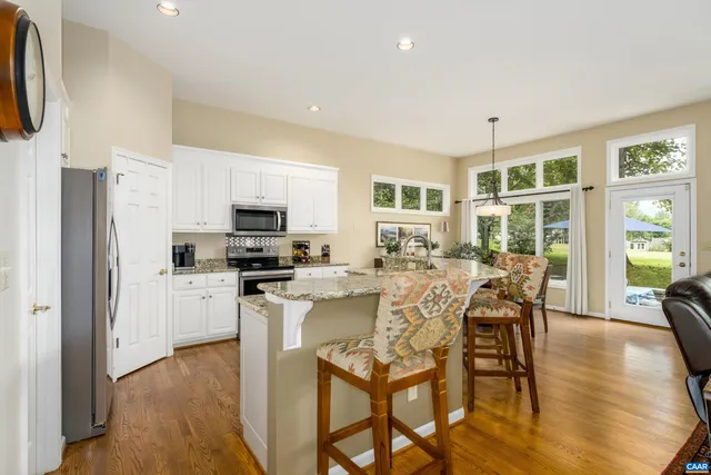 a kitchen with stainless steel appliances granite countertop a stove a sink and a wooden floors