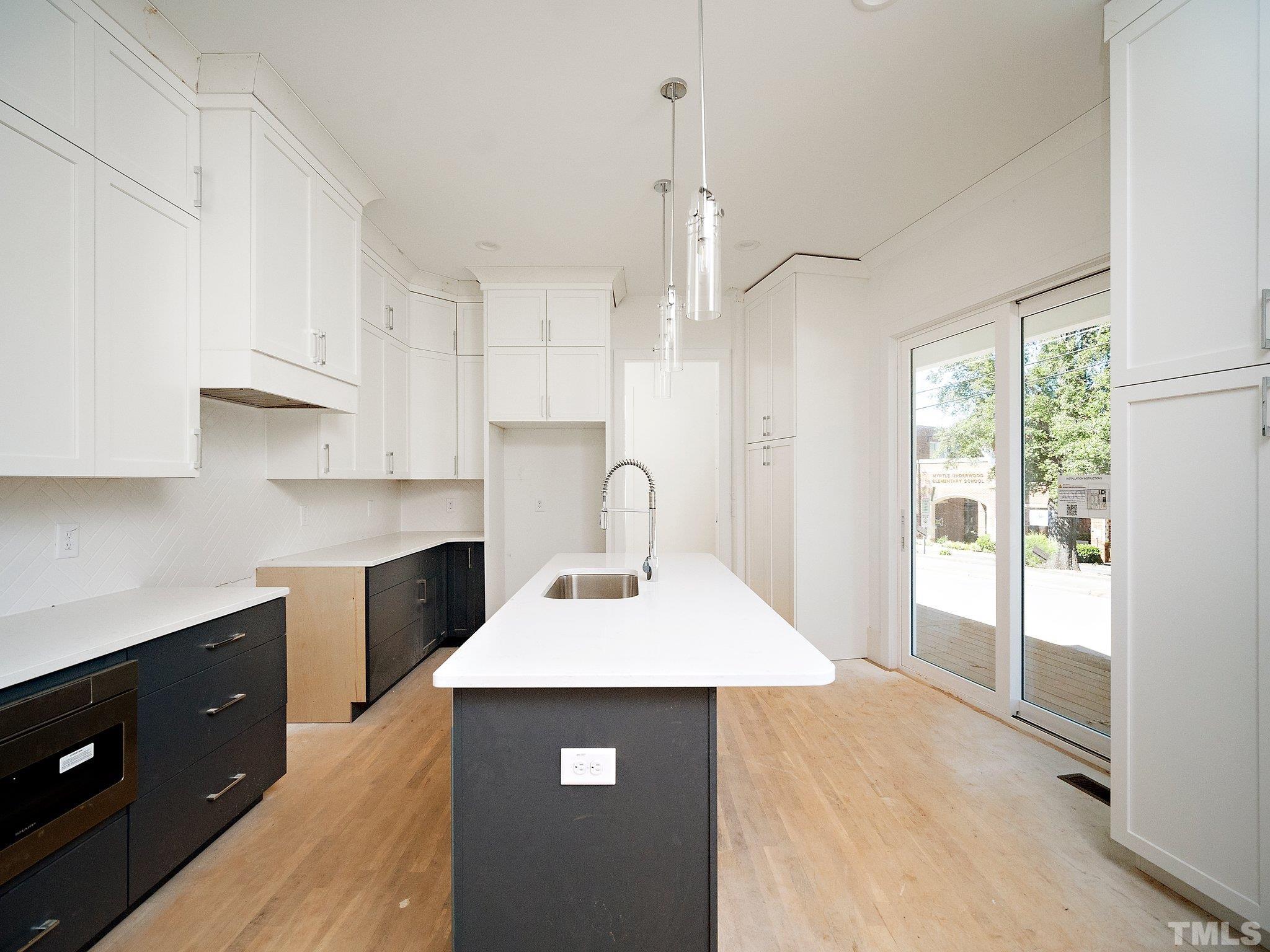 1811 Fairview Road Raleigh, NC 27608 - Photo 11 of 27 a kitchen with kitchen island a sink appliances and cabinets