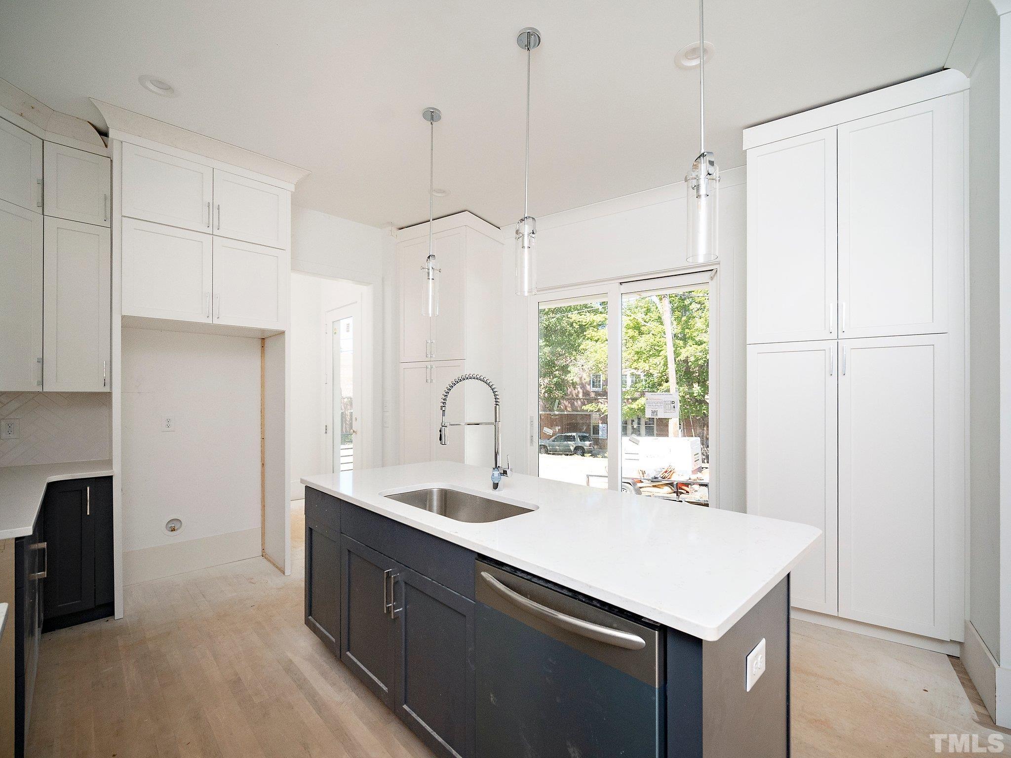 1811 Fairview Road Raleigh, NC 27608 - Photo 12 of 27 a kitchen with a sink a window and stainless steel appliances