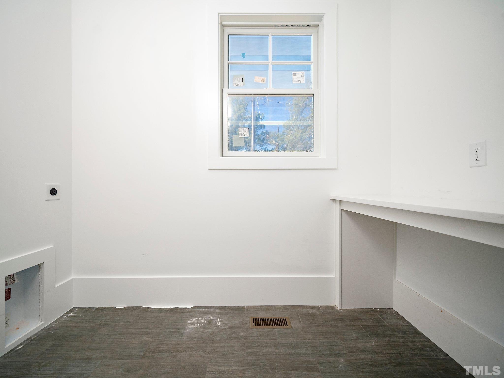 1811 Fairview Road Raleigh, NC 27608 - Photo 15 of 27 a view of an empty room with wooden floor and a window