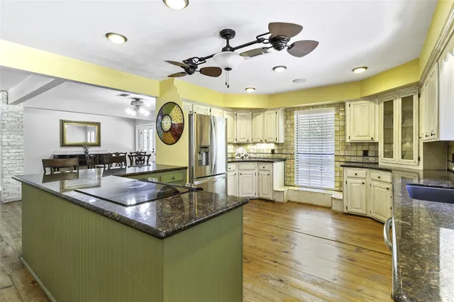 a kitchen with stainless steel appliances granite countertop a sink and a refrigerator