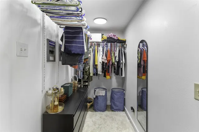 a view of walk in closet with clothes and shoes