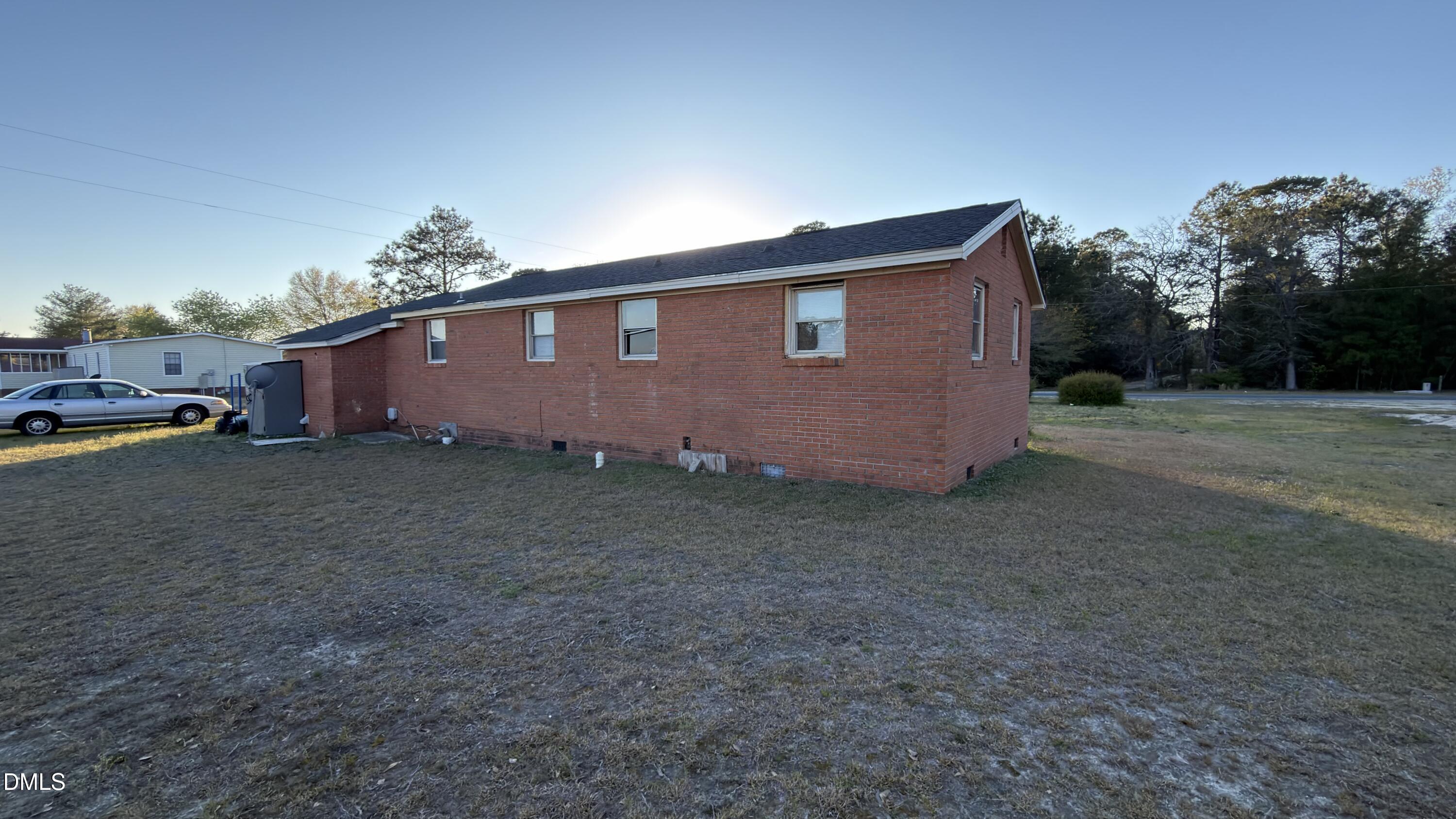 4803 Tabor Church Road Fayetteville, NC 28312 - Photo 22 of 25 a backyard of a house with lots of green space and a large tree