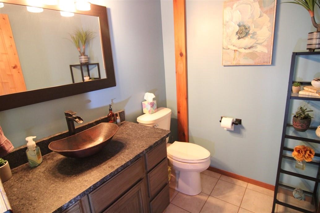 6492 Fitzgerald Road Rockford, IL 61102 - Photo 26 of 44 a bathroom with a granite countertop sink and a mirror