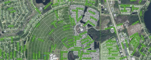 a backyard of a house with large trees and plants