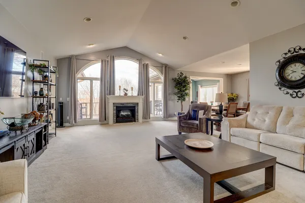 a living room with furniture a fireplace and a large window