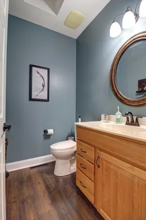 a bathroom with a toilet sink vanity and mirror