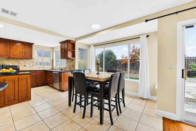 a open dining room with stainless steel appliances a sink and a refrigerator