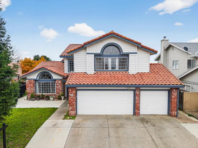 a front view of a house with yard and garage