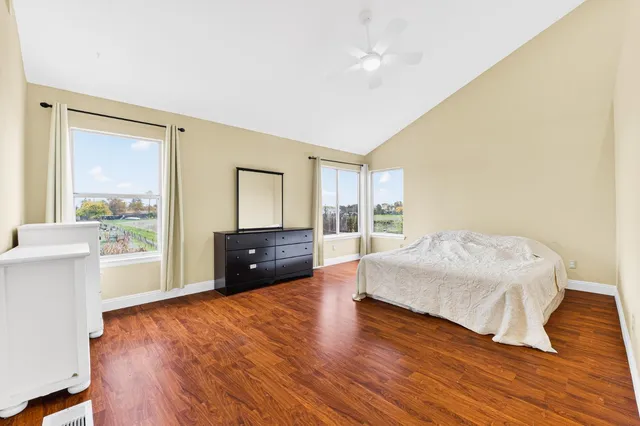 a bedroom with a bed and wooden floor